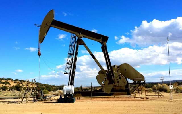 Oil pump jack silhouetted against a dramatic red sunset, symbolising oil market volatility