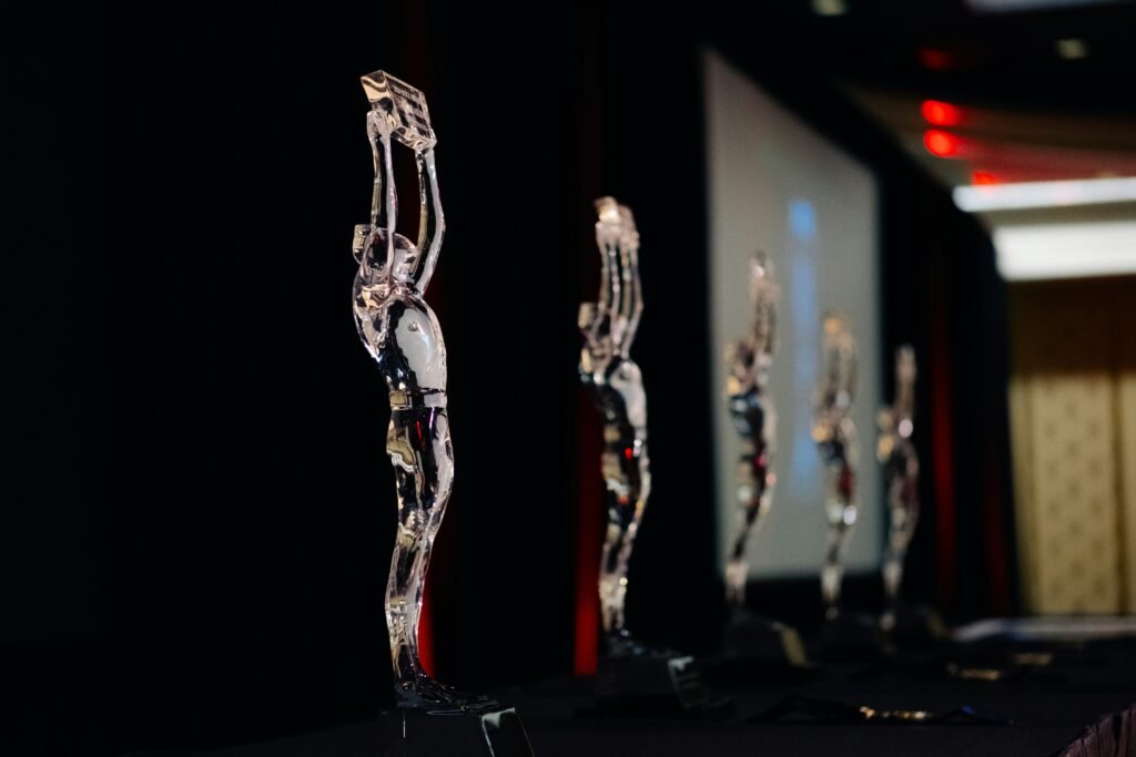 A gold business trophy displayed on a dark stage, representing prestigious global business awards and corporate excellence