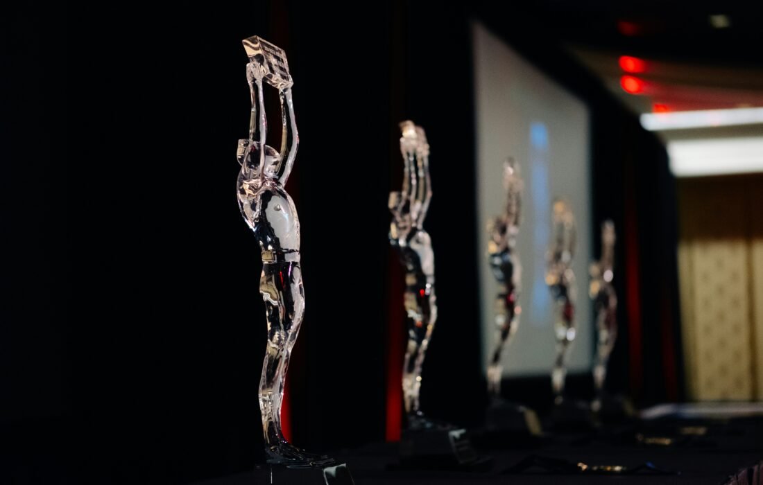 A gold business trophy displayed on a dark stage, representing prestigious global business awards and corporate excellence