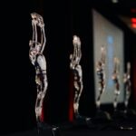 A gold business trophy displayed on a dark stage, representing prestigious global business awards and corporate excellence