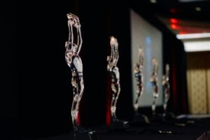 A gold business trophy displayed on a dark stage, representing prestigious global business awards and corporate excellence