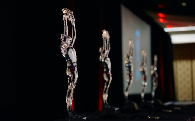 A gold business trophy displayed on a dark stage, representing prestigious global business awards and corporate excellence